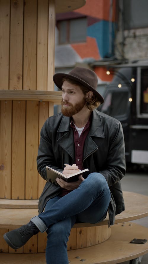 一个男人在他的笔记本上记笔记 · 免费素材视频