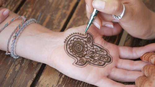 熟练的工匠在女人的手掌上绘制复杂的指甲花纹身 · 免费素材视频