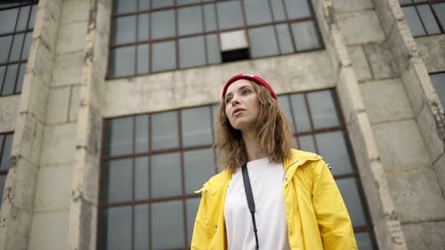 一个女人穿着红色无檐小便帽和黄色外套的特写视图 · 免费素材视频
