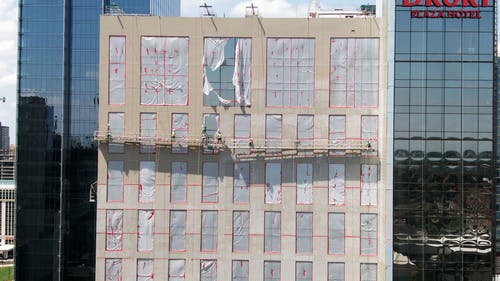 在一栋建筑的吊臂上的工人 · 免费素材视频