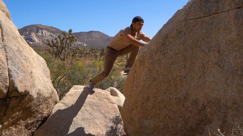 一个人爬上一块巨石 · 免费素材视频
