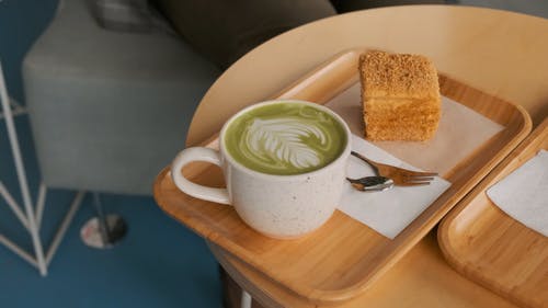 一个女人在一家咖啡馆内的笔记本电脑上工作，点咖啡和糕点 · 免费素材视频