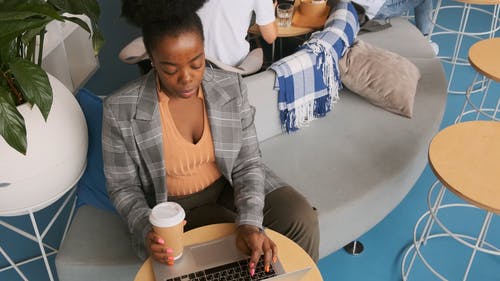 一个女人在一家咖啡馆内的笔记本电脑上工作 · 免费素材视频
