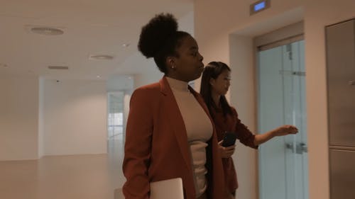 两个女人互相交谈时进入一个电梯 · 免费素材视频