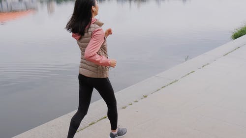一个女人在河边慢跑 · 免费素材视频
