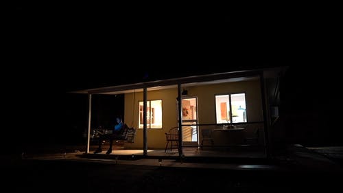 人坐在秋千上的房子的门廊 · 免费素材视频