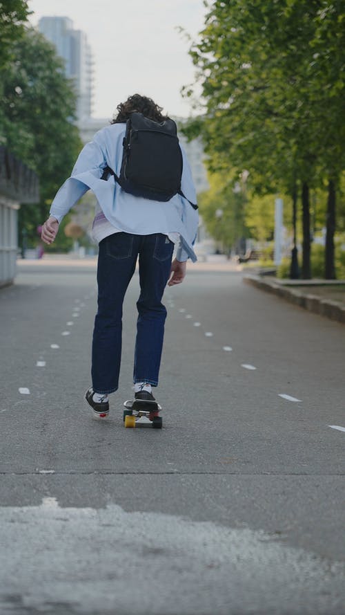 一个在街上玩滑板的年轻人 · 免费素材视频