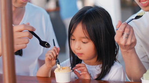 一个在纸碗里吃冰淇淋的女孩 · 免费素材视频