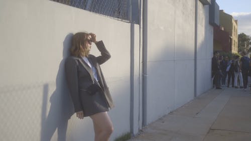 一个女人靠在姿势的墙上 · 免费素材视频