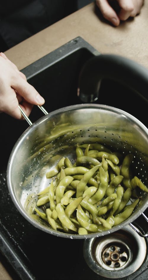 从煮熟的大豆豆荚中沥干水分 · 免费素材视频