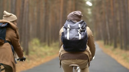 两人在空荡荡的道路上骑自行车 · 免费素材视频