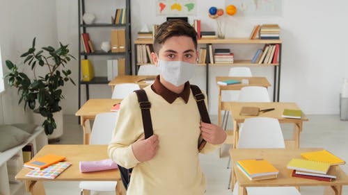 一个小男孩在教室里戴着面具 · 免费素材视频