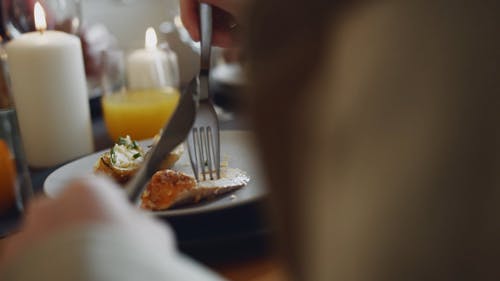 一个男孩在他的祖母一起吃饭的时候在一块切肉的切片 · 免费素材视频