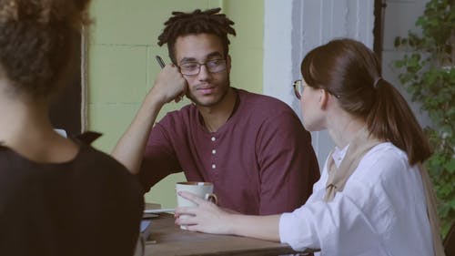 一个男人和一个女人在喝咖啡休息时间在工作场所谈话 · 免费素材视频
