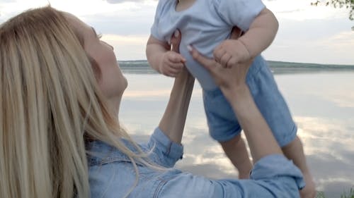 一位母亲调皮地抬起头顶的婴儿 · 免费素材视频