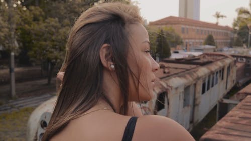 一个女人坐在废料场的垃圾火车顶上摆姿势 · 免费素材视频