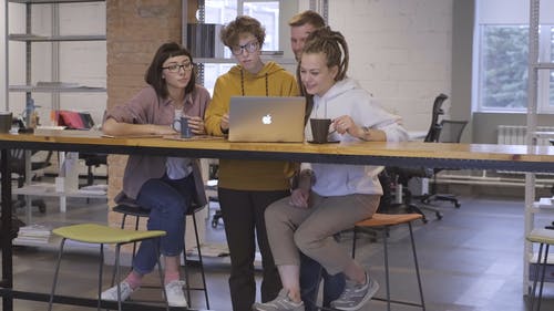 一群人在喝咖啡休息时间时使用一台笔记本电脑 · 免费素材视频