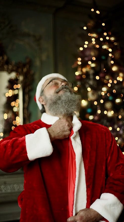 一位老人拉链他的圣诞老人服装 · 免费素材视频