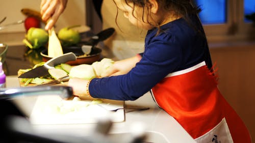 她的母亲在厨房里的儿童助手的镜头 · 免费素材视频
