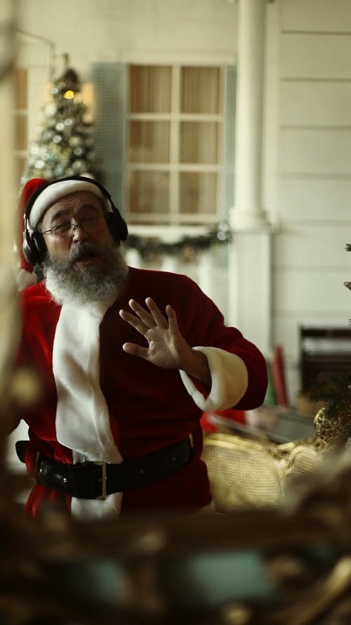 圣诞老人在他的耳机上跳舞听音乐 · 免费素材视频