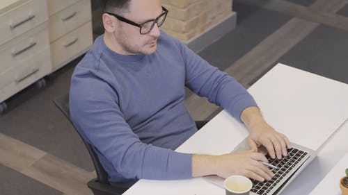 一个人在工作场所忙于使用笔记本电脑 · 免费素材视频