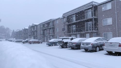 大雪覆盖了停放的汽车和地面上的平坦表面 · 免费素材视频