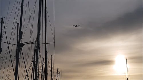 一架飞机飞越海湾，越过帆船在码头 · 免费素材视频