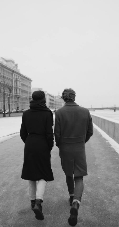 一对夫妇在寒冷的冬天在人行道上行走 · 免费素材视频