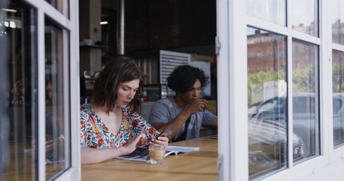 一个女人和一个男人在咖啡厅柜台喝咖啡 · 免费素材视频