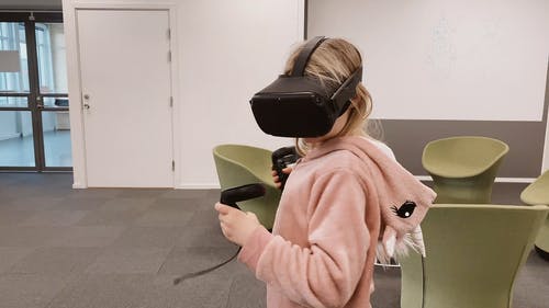 一个带着虚拟现实头部装备和控制器的孩子 · 免费素材视频