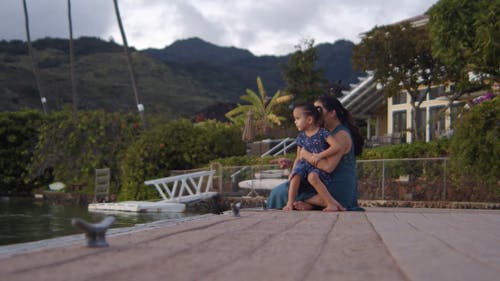 一位母亲和女儿坐在对接平台上欣赏自然风光 · 免费素材视频