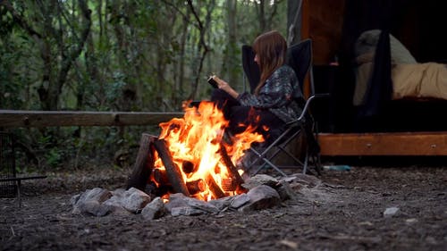 篝火与一个女人读一本书的慢动作镜头 · 免费素材视频