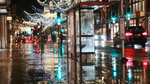 圣诞灯装饰在伦敦一条街的湿路面上的思考 · 免费素材视频