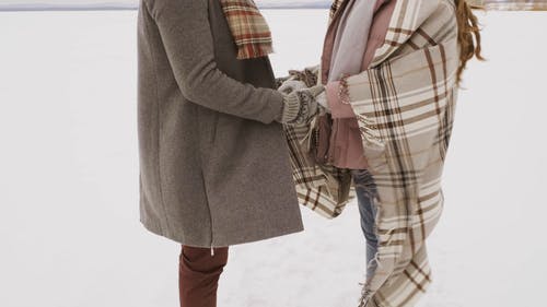 夫妇手牵着手在雪原中的镜头 · 免费素材视频