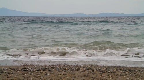 强烈的海浪将鹅卵石推向岸边 · 免费素材视频