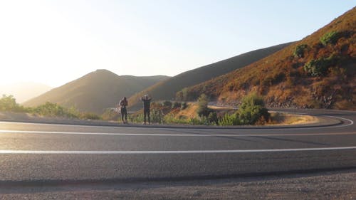 一个男人和一个女人在山路边停下来拍照 · 免费素材视频