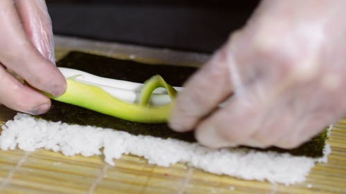 在海藻包装上撒上成分，使寿司卷 · 免费素材视频