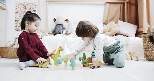 两个小孩在地板上玩木制玩具 · 免费素材视频