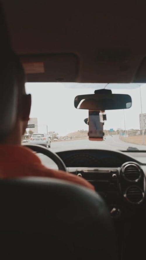 男子开车在电话上使用地图 · 免费素材视频