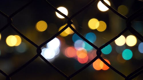 近摄镜头的方形铁丝网导致背景灯聚焦 · 免费素材视频