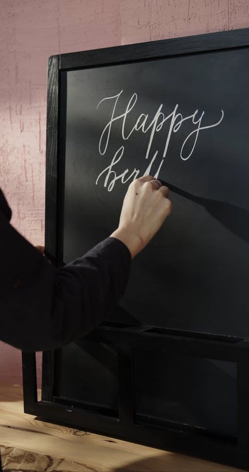 用粉笔在黑板上写书法的生日祝福 · 免费素材视频