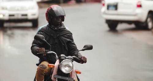 男子在潮湿的道路上骑摩托车 · 免费素材视频