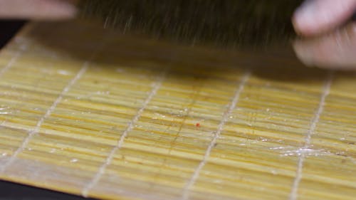 将煮好的米饭在紫菜纸上铺在竹卷上，制成寿司卷 · 免费素材视频