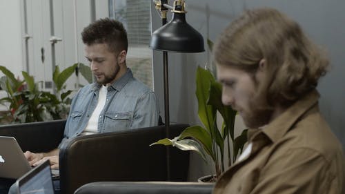 两名男子和他们的笔记本电脑一起工作并商定某事 · 免费素材视频