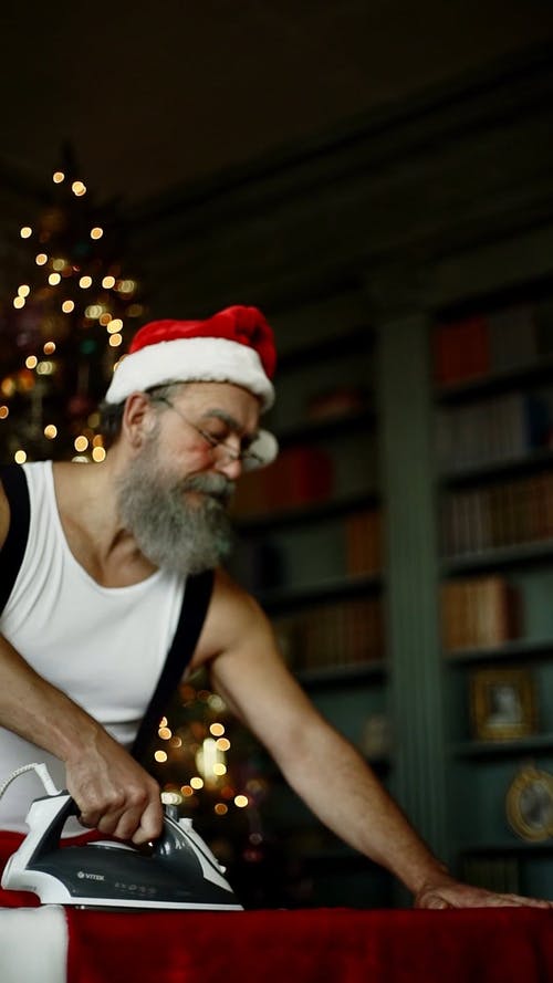 熨烫时想知道的圣诞老人服装的人 · 免费素材视频