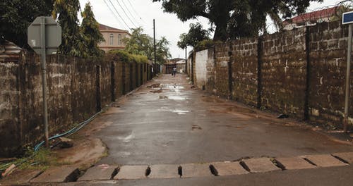 他下雨后弄湿了一条小巷的混凝土路面 · 免费素材视频