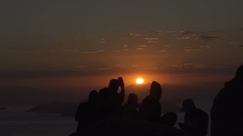 一群人在山顶上拍摄日落美景的镜头 · 免费素材视频