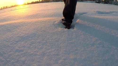 一个人在积雪覆盖的表面上行走，留下足迹 · 免费素材视频