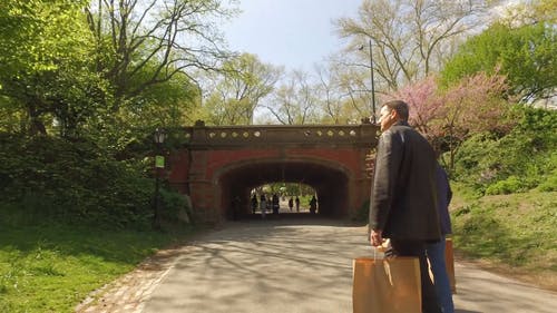两名男子步行穿过通往公园的隧道 · 免费素材视频