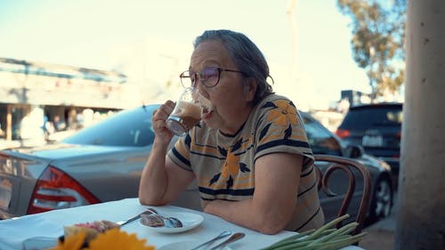 一个老妇在户外食堂喝一杯 · 免费素材视频